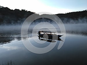 Tourist boat in the misty lake