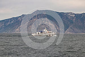 A tourist boat is moving along the coastline of Olkhon Island. Lake Baikal. High quality photos photo