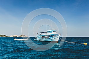 Tourist boat near island shore with turquoise clear transparent water