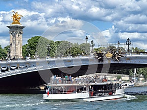 Tourist boat passing under the Alexander III bridge Pont Alexandre III