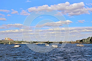 Tourist boats floating on the Neva river on the Troitsky bridge