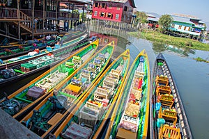 Tourist boats in Inle Lake with stilt houses in the background