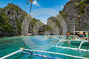 Tourist boats moored in a tranquil bay on turquoise waters of Sulu Sea.