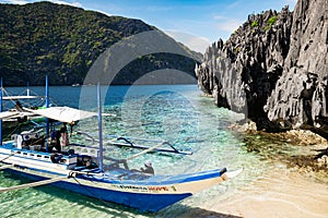 Tourist boats moored in a tranquil bay on turquoise waters of Sulu Sea.