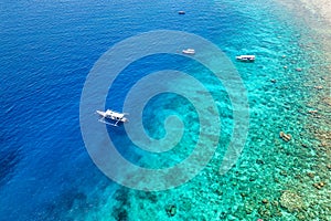 Tourist boats over the wall of a fringing coral reef in Indonesia