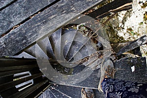 Tourist in boots walks on an old wooden spiral staircase