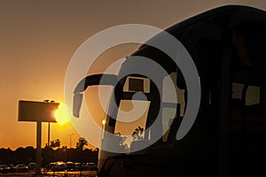 Tourist bus in the evening on a summer day against the background of a billboard and the setting sun