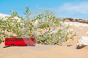Tourist bus model on the sand in desert. Summer tour