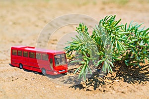 Tourist bus model on the sand in desert, summer travel