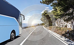 Tourist bus rushes along the country high-speed highway against the background of a mountain landscape.