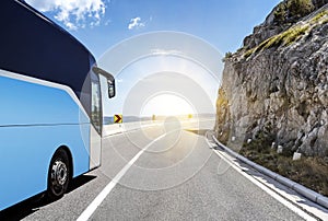 Tourist bus rushes along the country high-speed highway against the background of a mountain landscape.