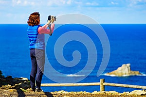 Tourist with camera on Asturias coast, Spain