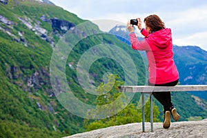 Tourist with camera looking at scenic view in mountains Norway