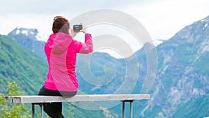 Tourist with camera looking at scenic view in mountains Norway