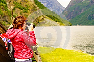 Tourist with camera near old viking boat, Norway