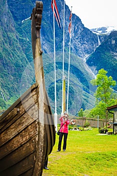 Tourist with camera near old viking boat, Norway