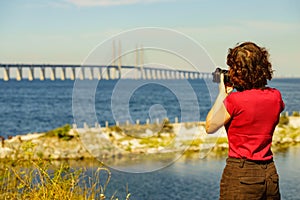 Tourist with camera and Oresund bridge Sweden