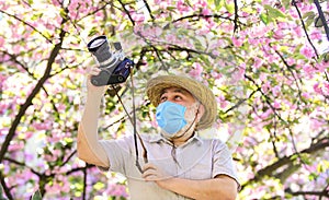 Tourist camera photo. Nature photography. Senior man respirator mask. Professional photographer work during coronavirus