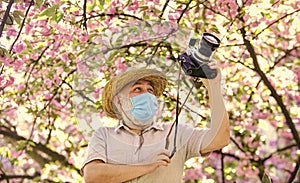 Tourist camera photo. Nature photography. Senior man respirator mask. Professional photographer work during coronavirus