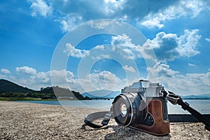 Tourist camera placed on the cement floor with the sky and the sea as the background