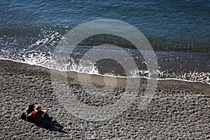 Tourist in Camogli`s beach in the fishing village of Camogli, Gulf of Paradise, Portofino National Park, Genova, Liguria, Italy