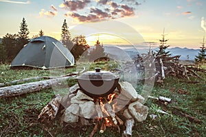 Tourist camp with fire, gree tent and firewood