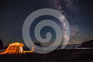 Tourist camping at sea coast at night with milky way
