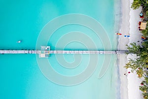 Tourist canoeing by wooden pier in turquoise sea and the beach on summer at tropical island