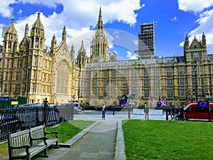 Tourist and cars in front of Westminster Houses of Parliament.