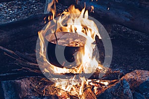 Tourist cauldron on fire. Food cooking in camping pot. Soup or chowder outdoors meal. Wildlife lifestyle, living in nature