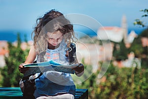 Tourist child girl with map traveling on summer vacations in Piran