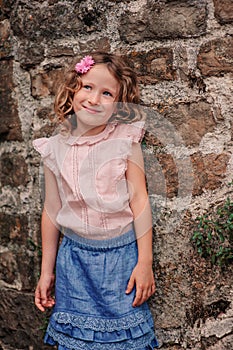 Tourist child girl at stone wall on the walk in Piran, Slovenia