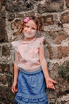 Tourist child girl at stone wall on the walk in Piran, Slovenia