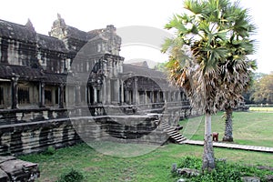 Tourist couple cycling around Angkor temple, Cambodia. Ta Keo building ruins in the jungle. Eco friendly tourism