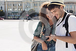 Tourist couple looking at photos on camera