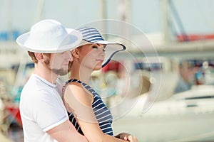 Tourist couple in marina against yachts in port