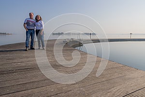 Tourist couple, a Mexican woman and a Dutch man on the wooden platform in the natural pool in the Woldstrand Zeewolde beach