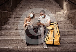 Tourist couple with protective face mask worried about new travel restrictions and quarantine