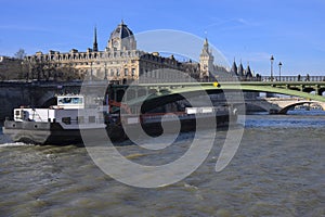 Tourist cruise boat sailing through the Seine River in front the Commerce Tribunal of Paris and the Concergerie