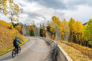 Tourist cycling on the Bow Valley Parkway in fall foliage season. Banff National Park, Canadian Rockies, AB, Canada. photo