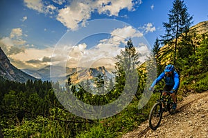 Tourist cycling in Cortina d`Ampezzo, stunning rocky mountains o