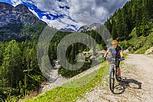 Tourist cycling in Cortina d`Ampezzo, stunning rocky mountains o photo