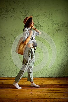 Tourist in a denim jacket and hat with a camera and bag. Happy emotions