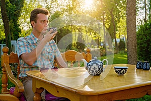 Tourist drinking tea from pials outdoors. Samarkand, Uzbekistan