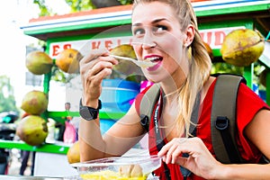 Tourist eating food at Indonesian street kitchen