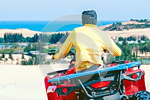 Tourist enjoy riding the quad bike or powerful fast off-road four-wheel drive ATVs at white sand dunes