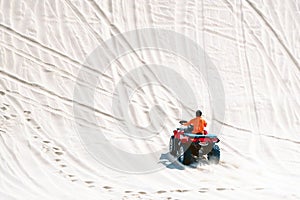 Tourist enjoy riding the quad bike or powerful fast off-road four-wheel drive ATVs at white sand dunes