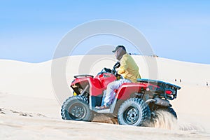 Tourist enjoy riding the quad bike or powerful fast off-road four-wheel drive ATVs at white sand dunes