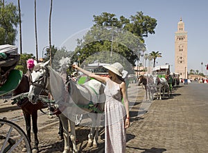 Tourist enjoying the carriages of the Jamaa el Fna square which is the central square of Marrakech, the most important place.