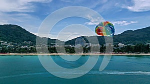 Tourist is enjoying a parasailing ride at Patong beach in Phuket of Thailand. Water sport activity. Thailand extreme